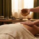 Un thérapeute verse de l'huile chaude depuis un bol en bois sur le dos d'une personne recevant un massage ayurvédique relaxant.