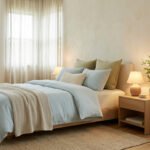 Une chambre Feng Shui lumineuse et apaisante avec un lit bleu clair, mobilier en bois, plante verte et tableau mural.