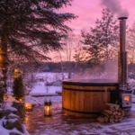 bain nordique en bois dans un jardin enneigé avec poêle fumant